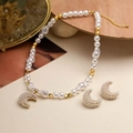 Elegant gold crescent moon earrings and baroque pearl necklace set on wooden stand - Gold Pearl Crescent Moon Set