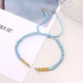 Adjustable light blue braided cord bracelet with polished gold metal beads - Light Blue