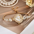 Detailed shot of a gold heart-shaped quartz watch with diamond bezel and adjustable chain - White