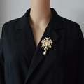 Vista dettagliata di una spilla barocca vintage con finitura dorata e perle su un abito nero - Stile 2 (Stile moneta fiore vintage) / Oro