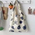 Detail of canvas tote bag with blue seashell prints hanging on a wall hook in a minimal room - Navy Blue Shell Sea Star Pattern