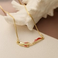 Detail van gouden vis hanger met rood emaille en kristallen aan de halsketting - Koi Vis-Zirkonia