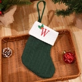 Green knit Christmas stocking with red letter W embroidery and festive berries - Letter W