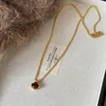 Primer plano de colgante de ojo de tigre con cadena dorada sobre bandeja de tela suave - 4# Estilo de Cadena de Metal Con Ojo de Tigre Redondo
