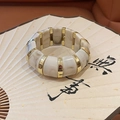 Primer plano de pulsera de acrílico marmoleado sobre abanico con espaciadores dorados - Dorado-Blanco Crema (HB3440)