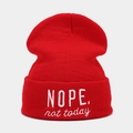 Close-up of red knit beanie featuring white embroidered NOPE text and ribbed texture - M (56-58cm) / Red