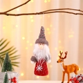 Dettaglio di uno gnomo di Natale con ricamo di fiocchi di neve bianchi su abito rosso - Babbo Natale
