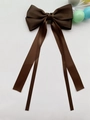 Dettaglio del fiocco per capelli in raso marron cioccolato con lunghi nastri setosi - Marrone