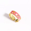 Détail de la bague fleur en émail rose avec bordure perlée dorée et anneau ajustable - Style Fleur Rose / Rose
