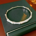 Dettaglio del bracciale stile bambù placcato oro con intarsio in madreperla su pelle - Argento