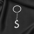 Silver stainless steel keychain with minimalist S letter pendant on dark fabric - S