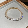 Detailaufnahme des goldenen Tennisarmbands mit funkelnden Zirkonia auf grauem Samt - Gold-Weiß (18K Vergoldet)
