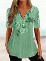 Detalle de la camisa con estampado floral verde que muestra el escote en V y botones - S / Tops / Verde