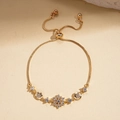 Detailed close-up of adjustable gold snowflake flower bracelet with sparkling crystals - Gold