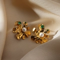 Close-up of gold wavy earrings with white pearl and emerald green stones on silk - Irregular Green Gem Pearl