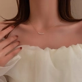 Dettaglio di una collana geometrica dorata con perle bianche indossata da una modella - Stile Geometrico con Perle Oro (53#)