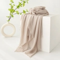 Beige pleated cotton linen scarf with fringe edges draped over a white cube base - Light Khaki