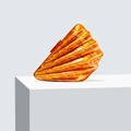 Macro shot of an amber acrylic shell clutch bag on a white geometric display stand - Orange