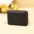 Close-up of black PU leather accordion coin purse with gold zipper and round pendant - Black