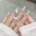 Close-up of nude gradient press-on nails with 3D white butterfly and rhinestone details - By1600 Pink And White Feather Wings / Glue Type