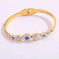 Detail view of gold-plated evil eye hinge bracelet with blue enamel and clear crystals - Big and Small Blue Eye Open Bangle