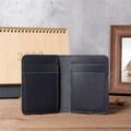 Vintage navy leather bifold card holder with 4 interior slots on a wooden desk - 1088 Blue