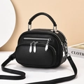 Minimalist black lychee pattern crossbody bag with double zippers on white platform - Black