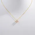 Macro shot of gold S925 silver four-leaf clover pendant necklace with shiny zircons - Gold Clover Necklace