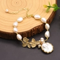 Baroque pearl bracelet with gold floral accents and a round pearl charm on wood - Bezel-Set Freshwater Pearl Bracelet