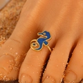 Adjustable gold seahorse toe ring with blue enamel detail on a sandy beach background - Blue Seahorse (11923)