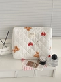 Detail view of quilted cream makeup bag with cute brown bear and red bow patterns - Bow Bear Handheld Bag