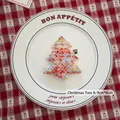 Knitted 9x8cm Christmas tree ornament in mixed orange and grey yarn on white plate - Christmas Tree A-03