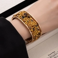 Detailed view of gold wide open bangle with pave crystals and tiger eye stones - Brown