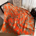 Detail of silk scarf with orange and beige abstract print draped near a handbag - Style 13