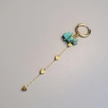Detail of gold drop earrings featuring turquoise stones and four heart charms on long chains - Turquoise