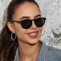 Classic black round sunglasses with metal rivets worn by a model in a denim jacket - Black