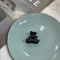 Matte black bear hair claw clip with heart cutout design on blue ceramic plate - Black