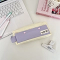 Detailed view of color-block pencil case with pink heart buttons on a desk setup - Beige