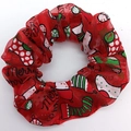 Close-up of red mesh hair scrunchie with Merry Christmas print and festive patterns - Christmas Stocking Shoe