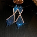 Macro shot of long drop earrings with blue rhinestones and sparkling silver metal base - Silver Earring Post-Blue