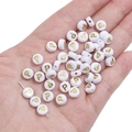White and gold letter P acrylic bead for DIY jewelry making on human palm - Letter P