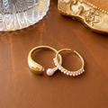 Detail of gold teardrop open ring and pearl accent band set on vintage display - Gold Teardrop Thickened and Pearl Ring Two-Piece Set