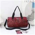 Detail of red camouflage travel bag with adjustable black shoulder strap and logo - Red