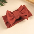 Detail of baby headband featuring large layered knit bow in rust red vintage style - Rust red