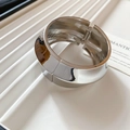Detailed view of polished silver wavy bangle with high-gloss finish and hinge closure - Silver - Twisted Wide