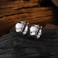 Macro view of S925 sterling silver pearl hoop earrings on dark wood background - White Gold