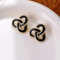 Orecchini vintage in smalto nero con design a cerchi dorati intrecciati su piatto bianco - Stud orecchini