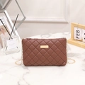 Brown quilted crossbody bag with gold chain strap and metallic buckle on white marble - Khaki