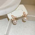 Détail de boucles d'oreilles papillon en émail rose avec perles et tiges en argent S925 - Tige d'oreille en argent sterling 925 - Rose (Style pendentif perle papillon)
