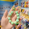 Portachiavi a bracciale con perle verdi effetto aurora, ciondolo orsetto e fiocco - verde chiaro